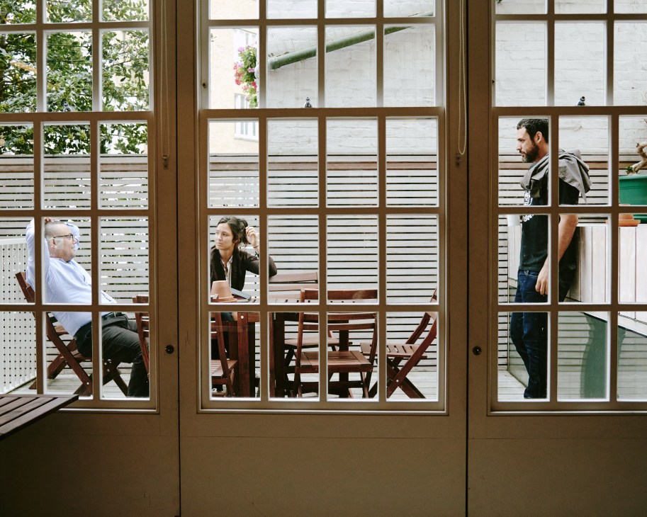 Interior view through large windows showing people working at the Delfina Foundation artist residency in London.