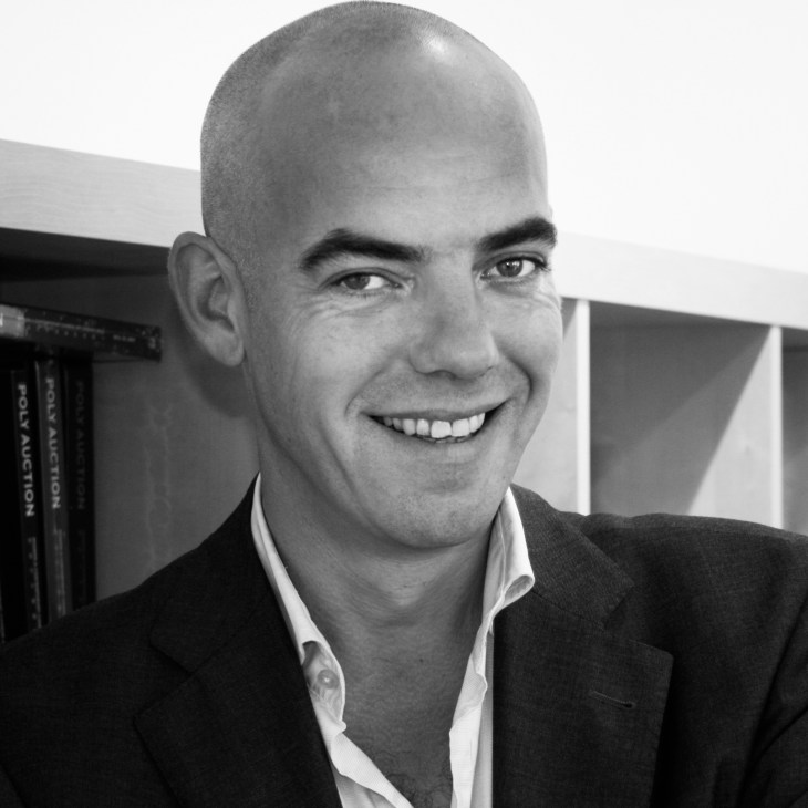 Black and white portrait of Fons Hof, Director of Object Rotterdam, smiling at camera in professional attire.