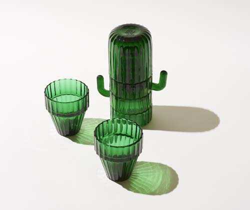 Three green cactus-shaped glasses stacked together with shadows on a white surface.