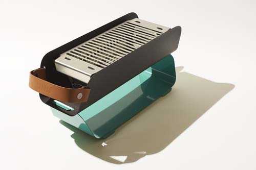 Una grill in mint green with stainless steel grates and wooden handles on neutral background.