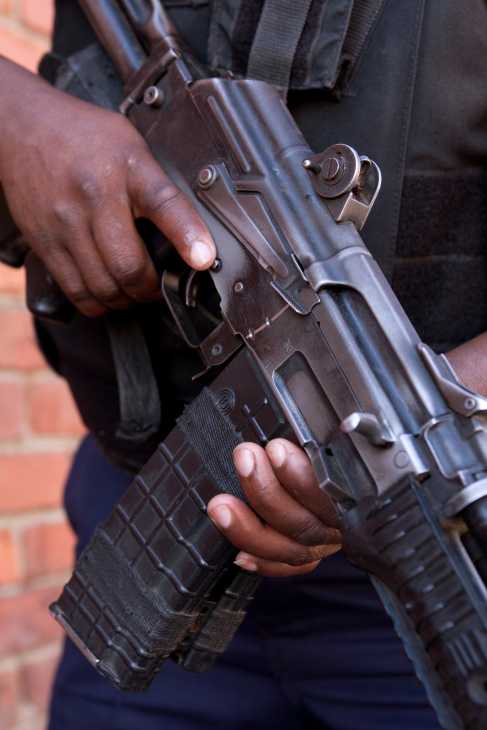 Armed security guard holding an assault rifle with ammunition magazine.