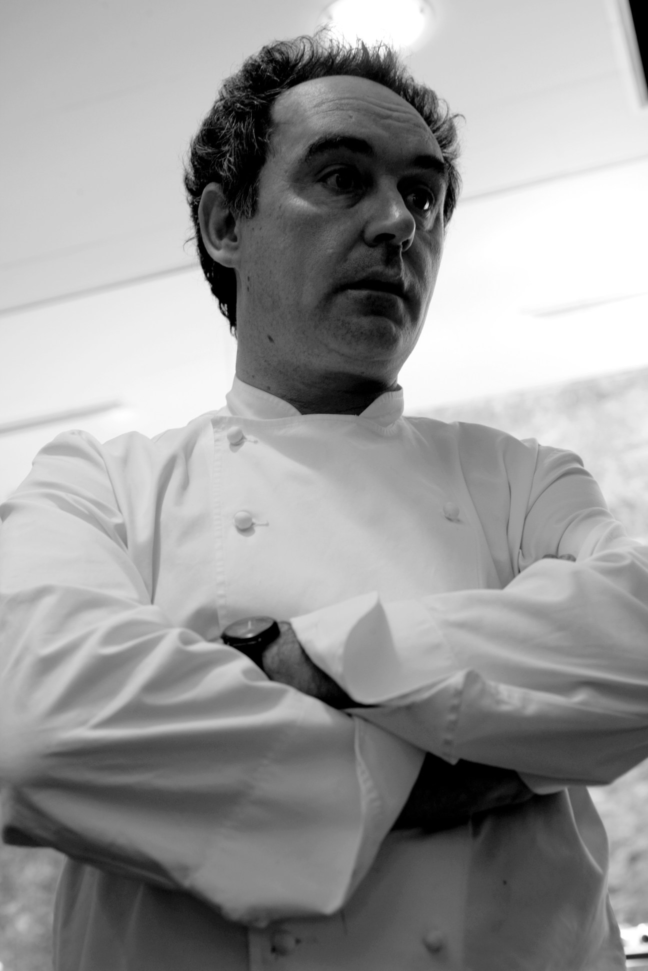 Black and white portrait of chef Ferran Adrià wearing a white chef's coat.