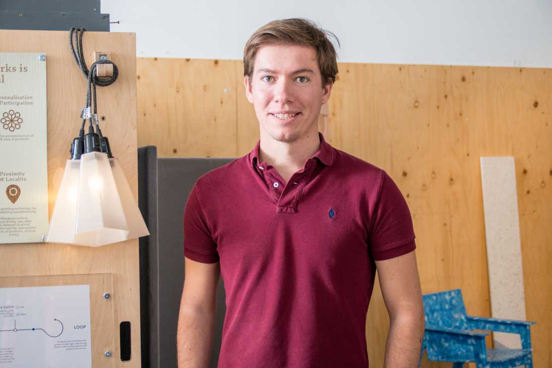 Julien Vaissieres, co-founder of BatchWorks, smiling in a workshop with wooden walls and hanging pendant light.