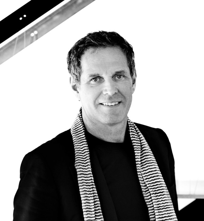 Black and white portrait of Kim Herforth Nielsen, founder of 3XN architects, wearing a striped scarf.