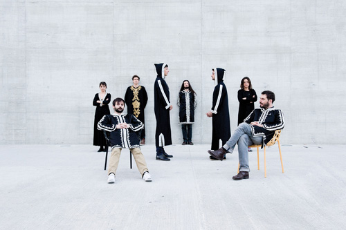 French jazz band Aquaserge posing in black and white clothing against a white brick wall.
