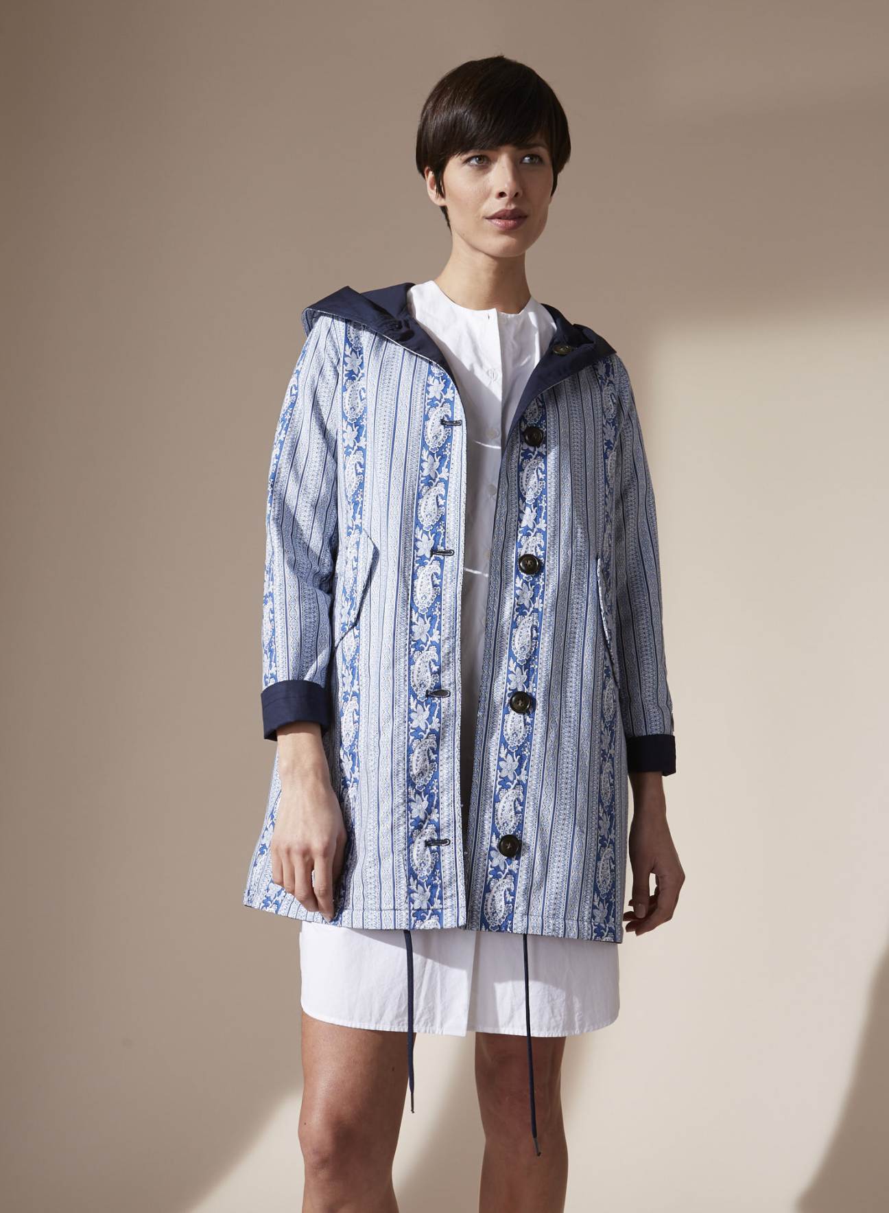Woman wearing Woolrich x Les Olivades reversible parka with blue and white printed pattern