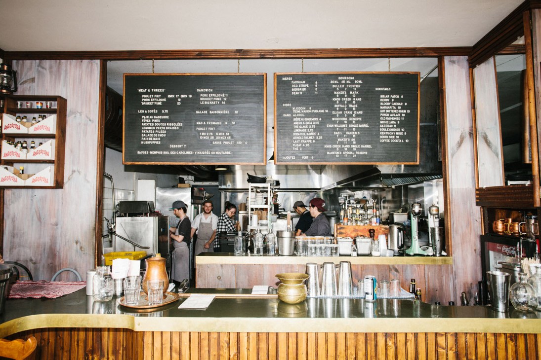 Interior of Mount Royal café with wooden counter, menu boards, and staff working behind the counter.