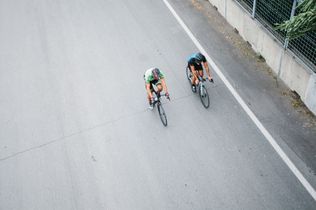 Two cyclists riding on a Formula 1 track at Jean-Drapeau island park in Montreal.