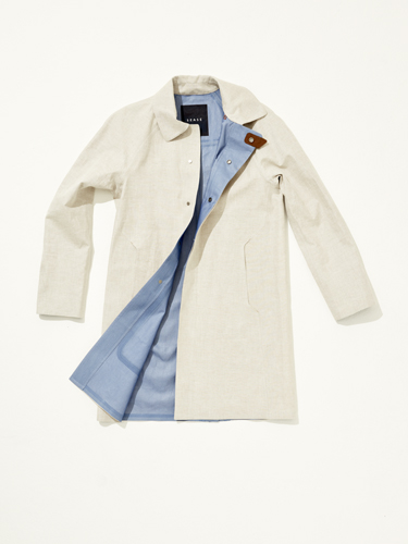 Cream-colored trench coat displayed open, showing light blue lining and brown toggle buttons.
