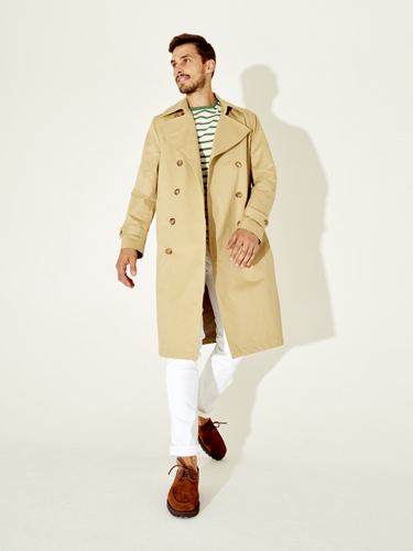 Man wearing a beige double-breasted trench coat, striped shirt, and brown shoes, representing Sunflower menswear.