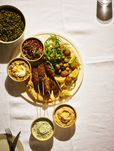 Swedish-style canapés arranged on a white plate with various dips and accompaniments.