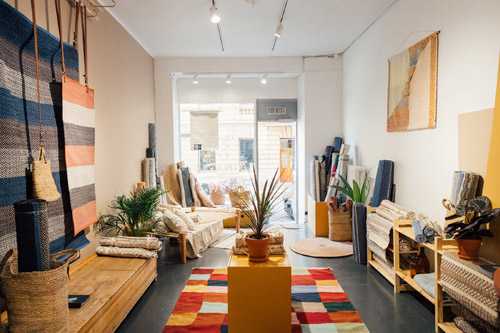 Interior of Finarte design store displaying Finnish rugs, textiles, and home décor items.