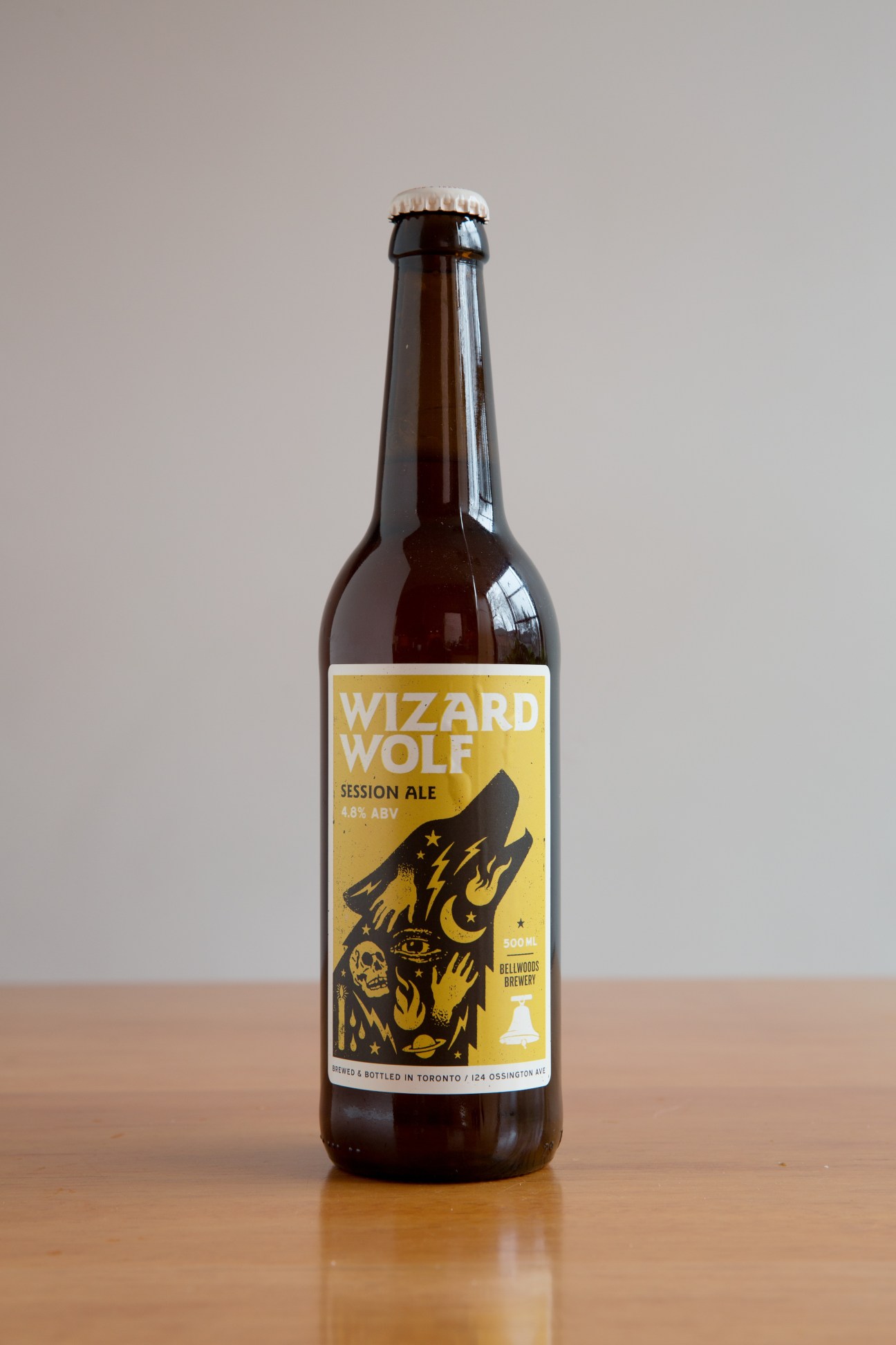 Bellwoods Brewery Wizard Wolf Session Ale bottle with yellow label and black wolf illustration.
