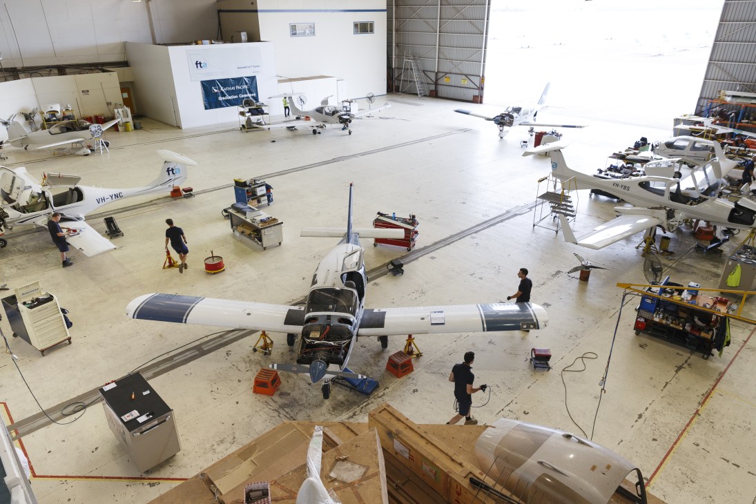 Overhead view of FTA hangar with multiple small aircraft undergoing maintenance and training operations.