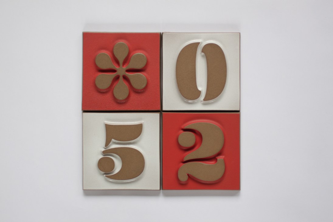 Heath Ceramics house number tiles featuring numbers inspired by Richard Neutra and Charles Eames fonts in paprika and white.