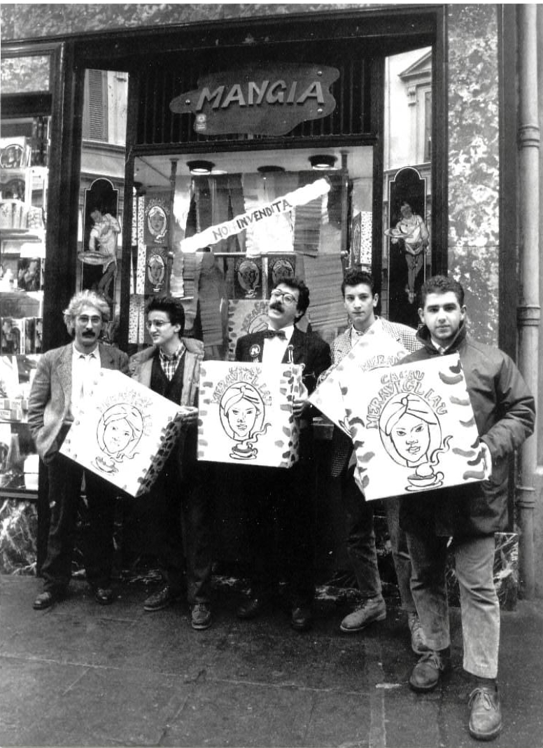 Black and white photograph of five men holding artwork outside the Mangia delicatessen storefront in Palermo.
