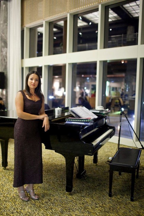 Svetlana Moreva, pianist, poses beside a grand piano in Le Royal Méridien hotel lobby in Abu Dhabi.
