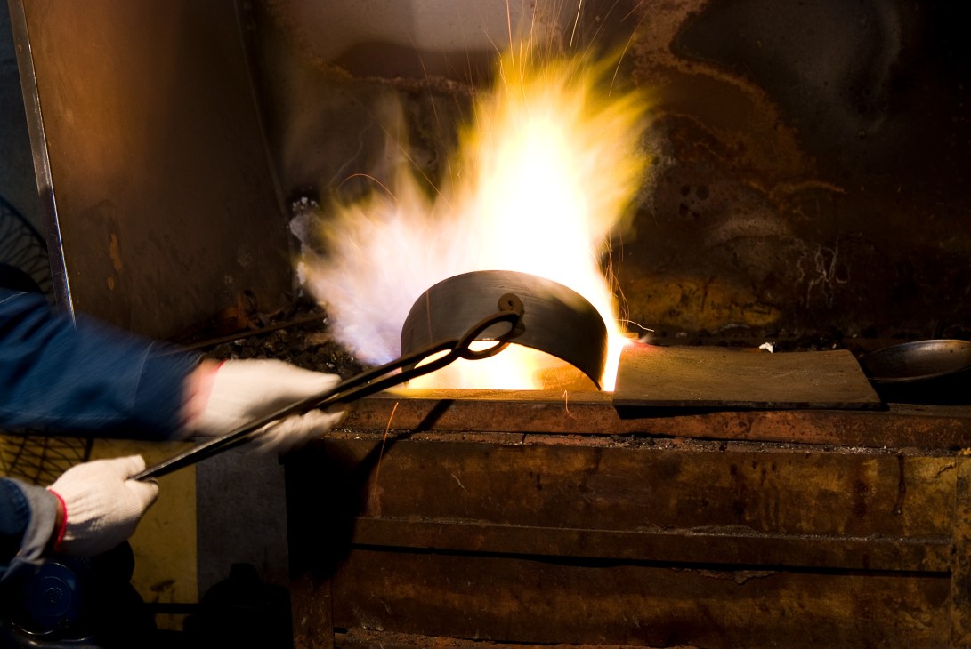 Molten bronze being poured into a mold during the casting process at Lee Bong-ju's workshop.