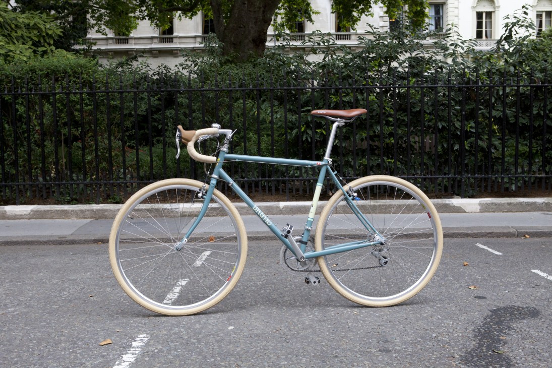 Bruno 700C City Tourer bicycle with blue frame and cream-colored tires parked on a Paris street.
