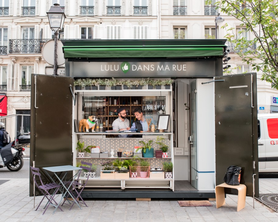 Lulu Dans ma Rue kiosk storefront in Paris with green awning and staff inside.