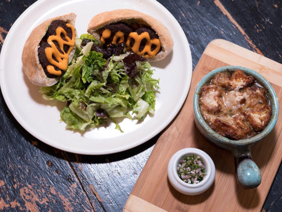 Burger with cheese and mustard served with green salad at Arts Café in Montréal.