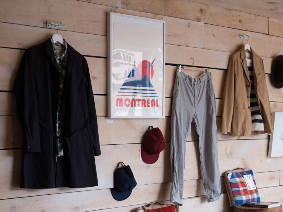 Menswear displayed on wooden wall at Clark Street Mercantile in Montreal's Upper Plateau.