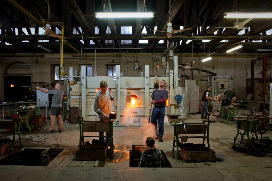 Glassmakers work with molten glass at furnaces in the Theresienthal factory in Bavaria.