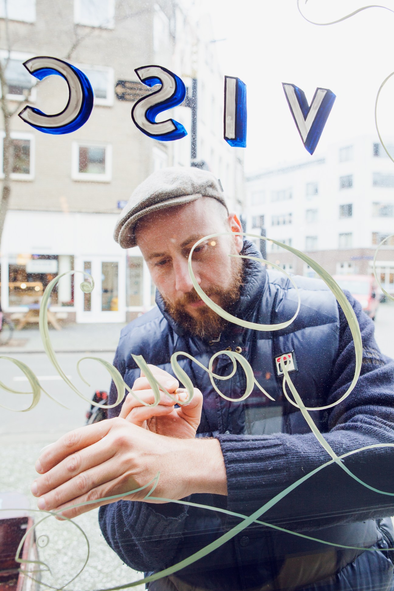 Jasper Andries painting traditional Amsterdamse Krulletter lettering on a window