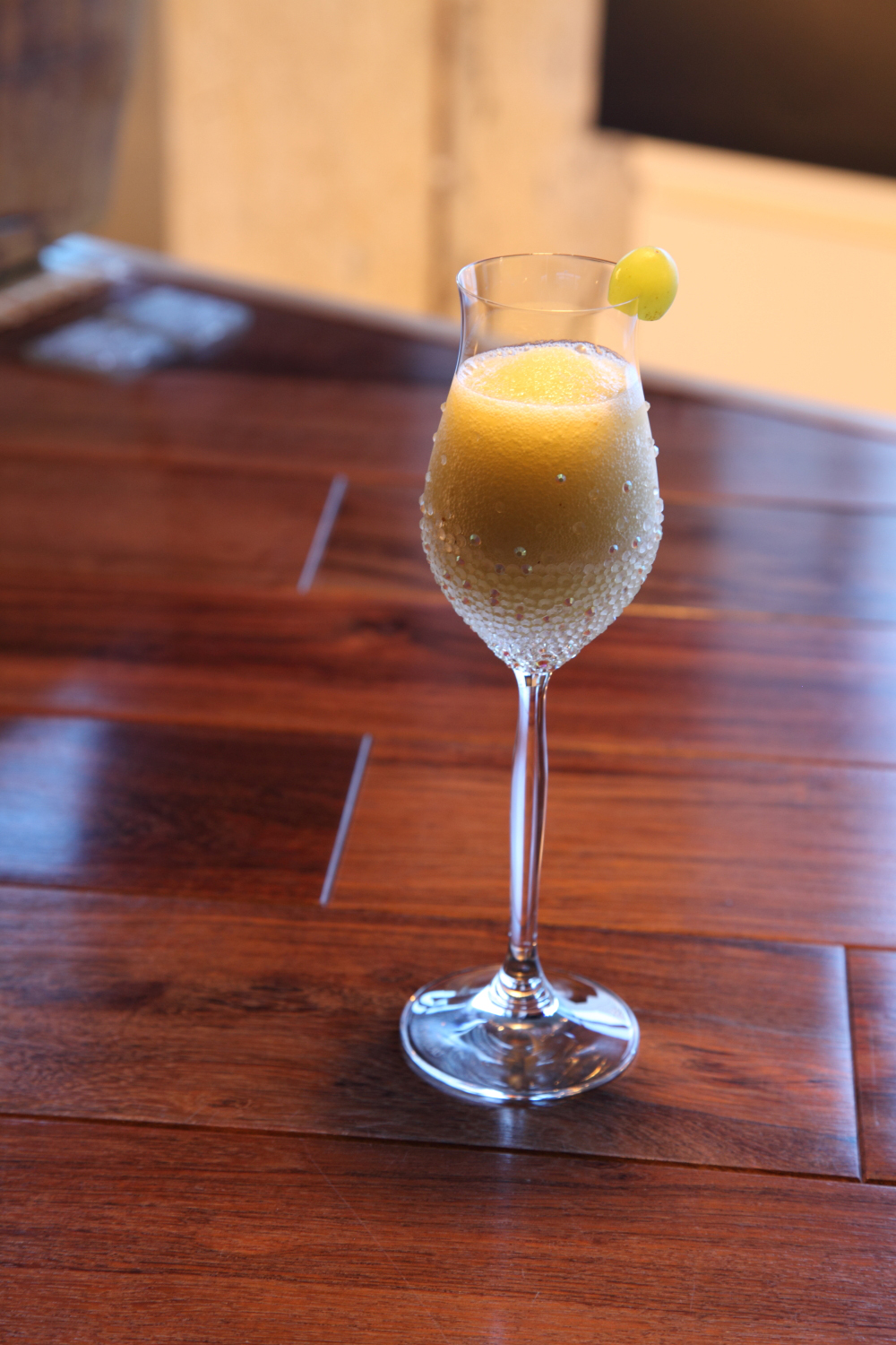 A layered cocktail of coffee, chocolate and cream garnished with a lime wheel in a wine glass.