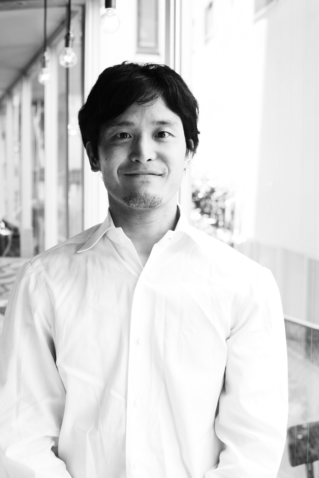 Black and white portrait of Shinji Fujikawa, CEO of Cheese Stand, in a white shirt.