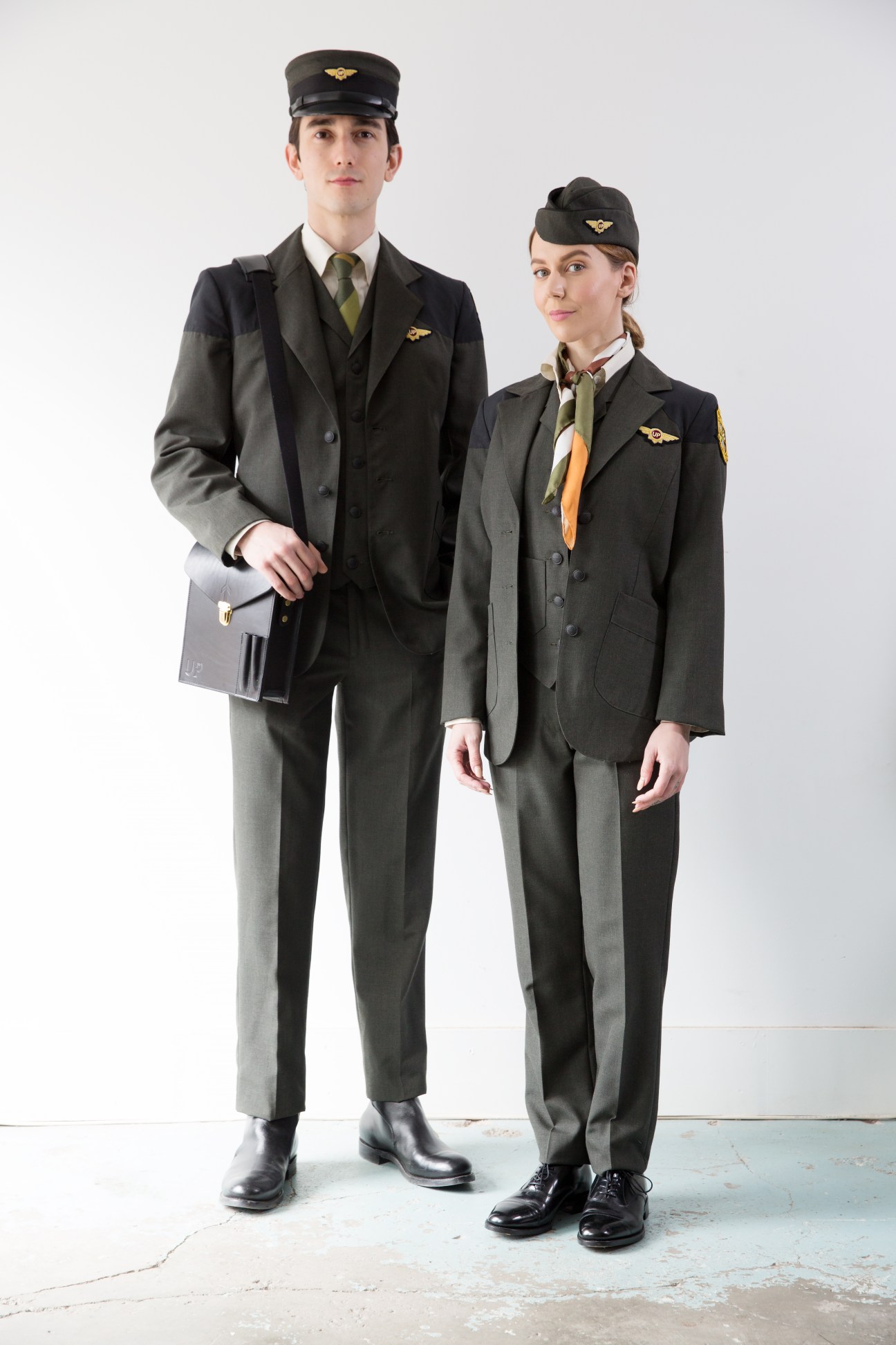 UP Express staff uniforms designed by Matt Robinson featuring forest-green blazers, caps with golden wings pins, and coordinating accessories.