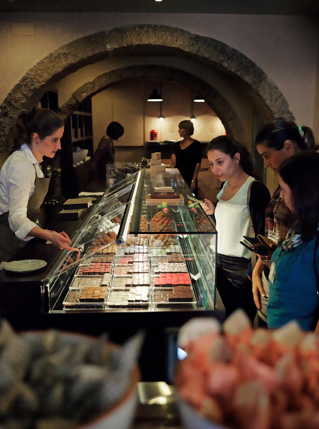 Customers browse chocolates and confections at Chocolataria Equador's counter in Lisbon.