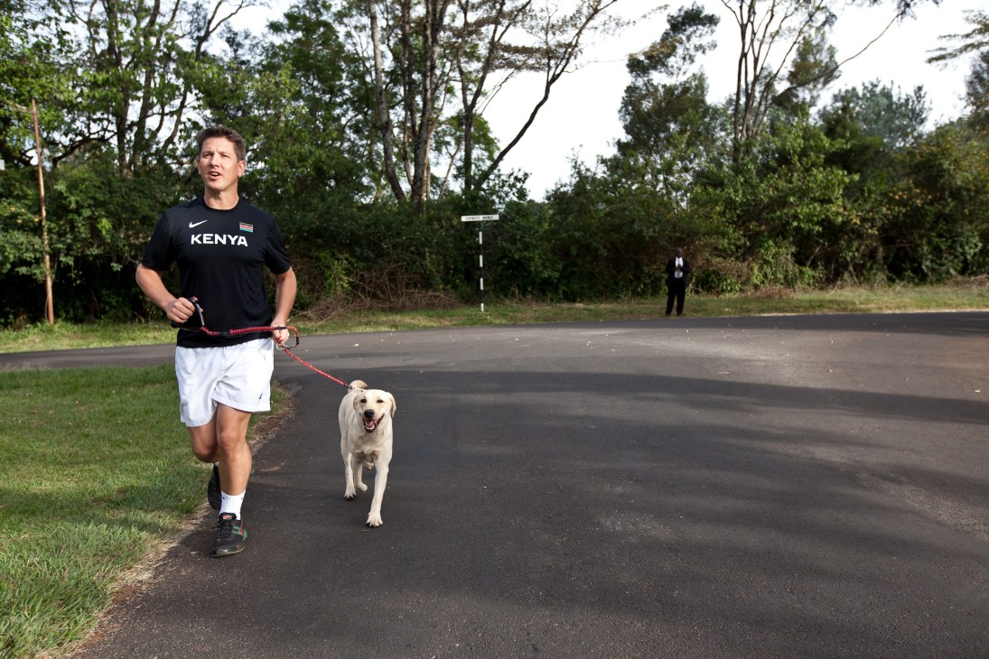 Christian Turner, UK high commissioner to Kenya, jogging with yellow labrador Tchui on a tree-lined road.