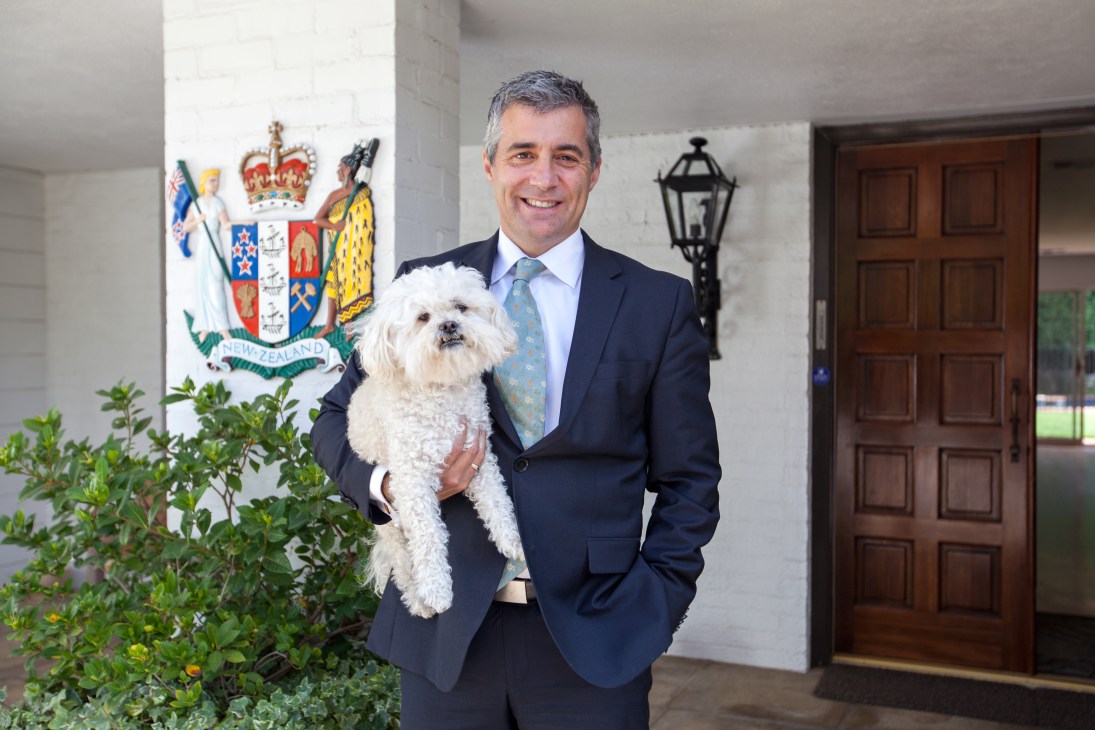 Leon Grice, New Zealand's consul-general to Los Angeles, holds Milou, his white bichon frisé dog, at the consulate entrance.