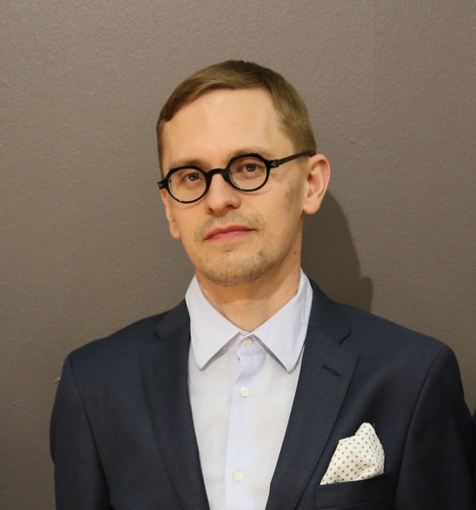 Portrait of Antti Rouhunkoski, co-founder and designer at Poiat, wearing glasses and dark blazer.