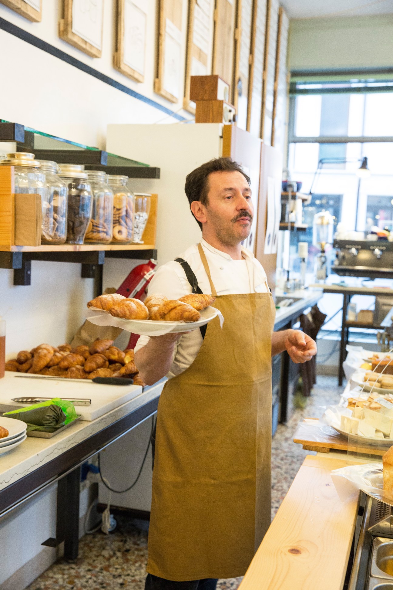 Federico Parise holds a plate of croissants in his café at Colazione in Bottega.