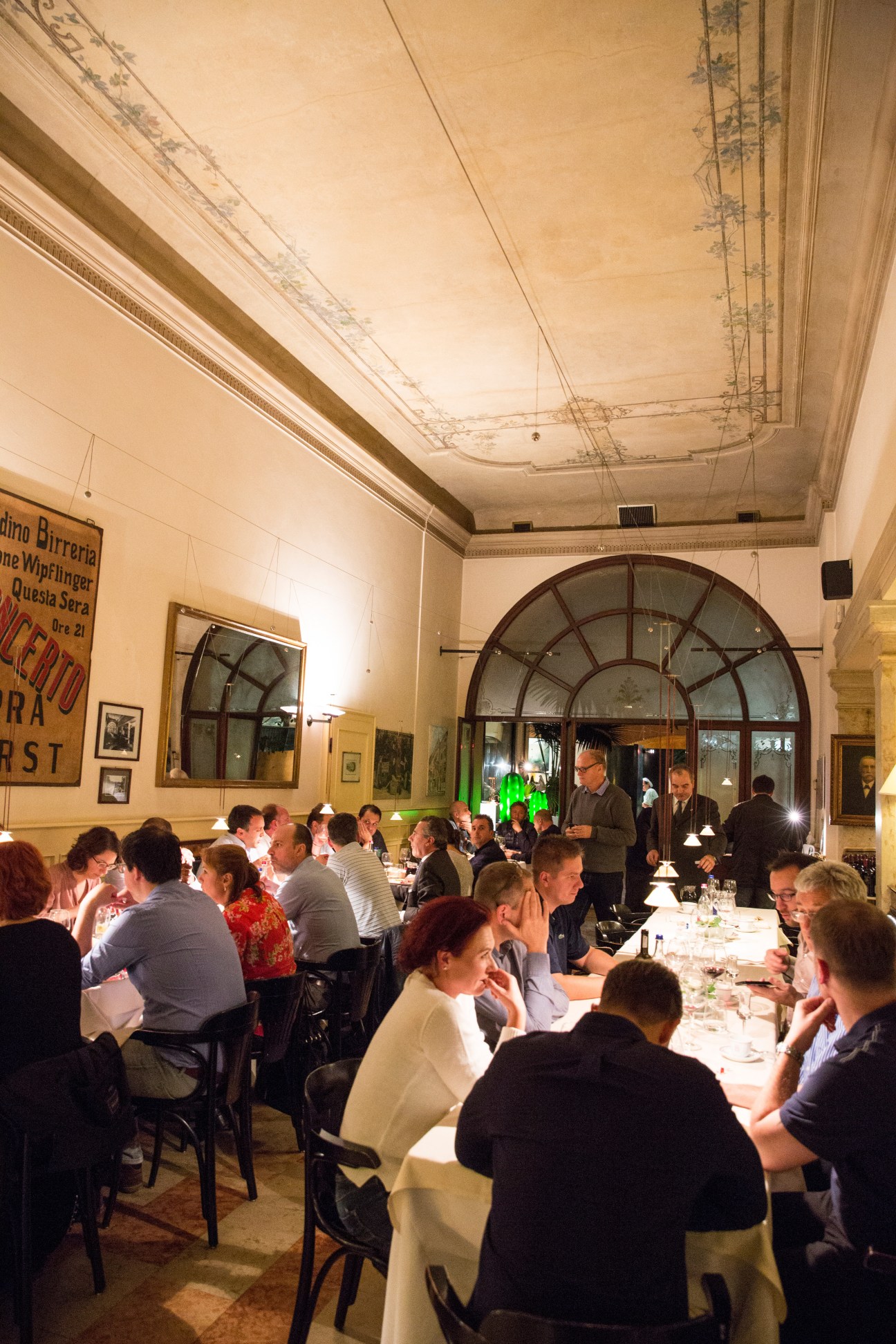 Diners seated at tables inside Ottone restaurant with art deco furnishings and ornate ceiling.