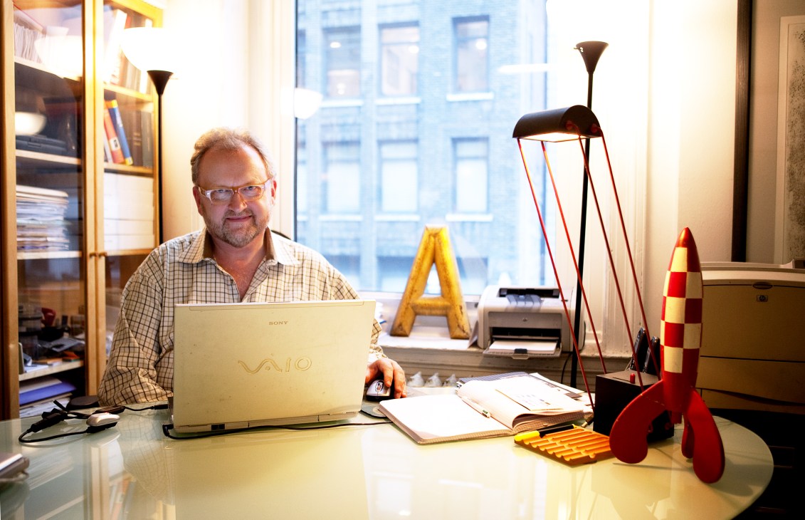 Mark Batty sits at his desk in his Manhattan office surrounded by colorful design objects and books.