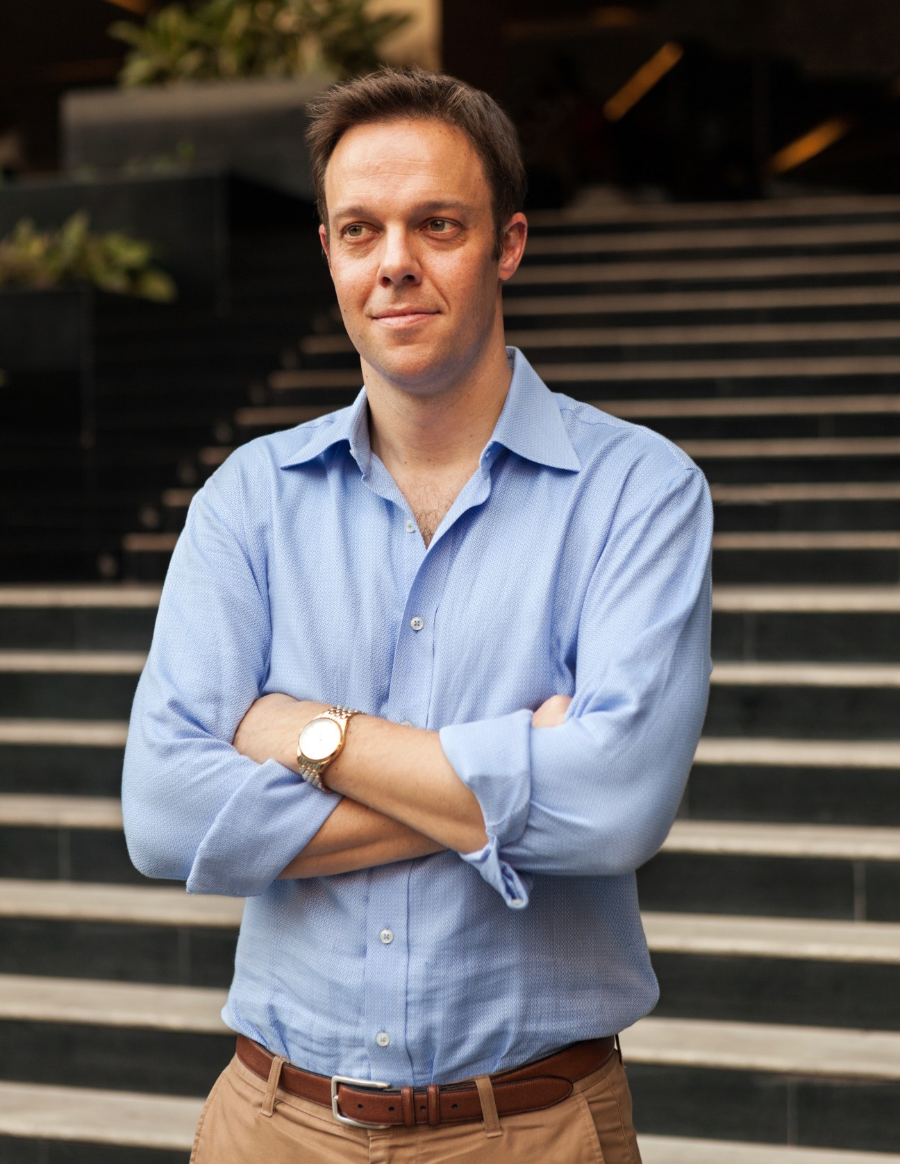 Blair Glencorse, head of the Accountability Lab NGO, stands with arms crossed wearing a light blue shirt.
