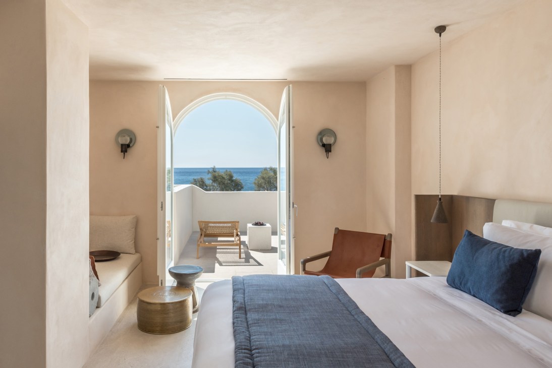 Santorini hotel suite with arched terrace doors opening to sea views and private pool area