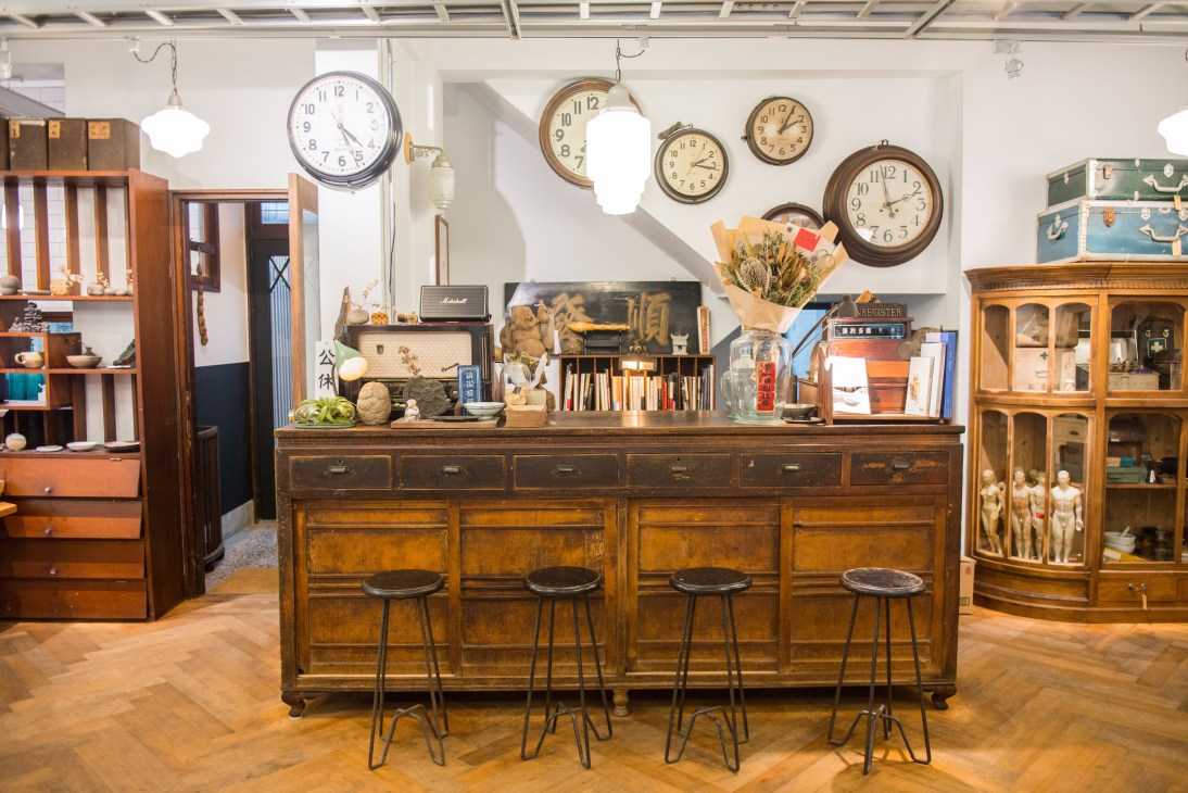 Vintage antique shop interior with wooden furniture, clocks, and collectibles at Paripari apartment in Tainan.