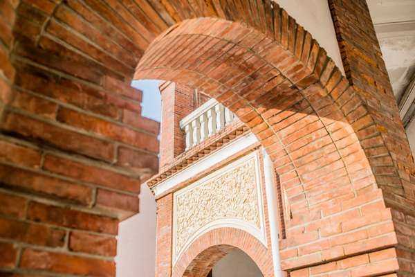 Brick archway entrance to the Old Tainan Magistrate Residence with ornate white detailing above the arch.