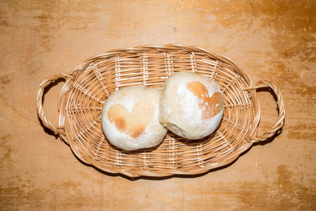 Two powdered buns with apricot jam filling in a wicker basket.