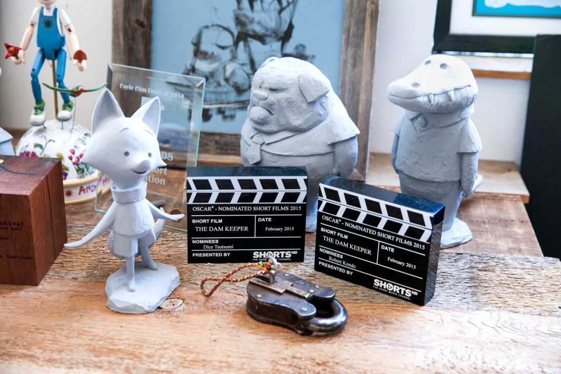 Tonko House studio desk displaying character figurines, Oscar nomination clapperboards for The Dam Keeper, and animation awards.
