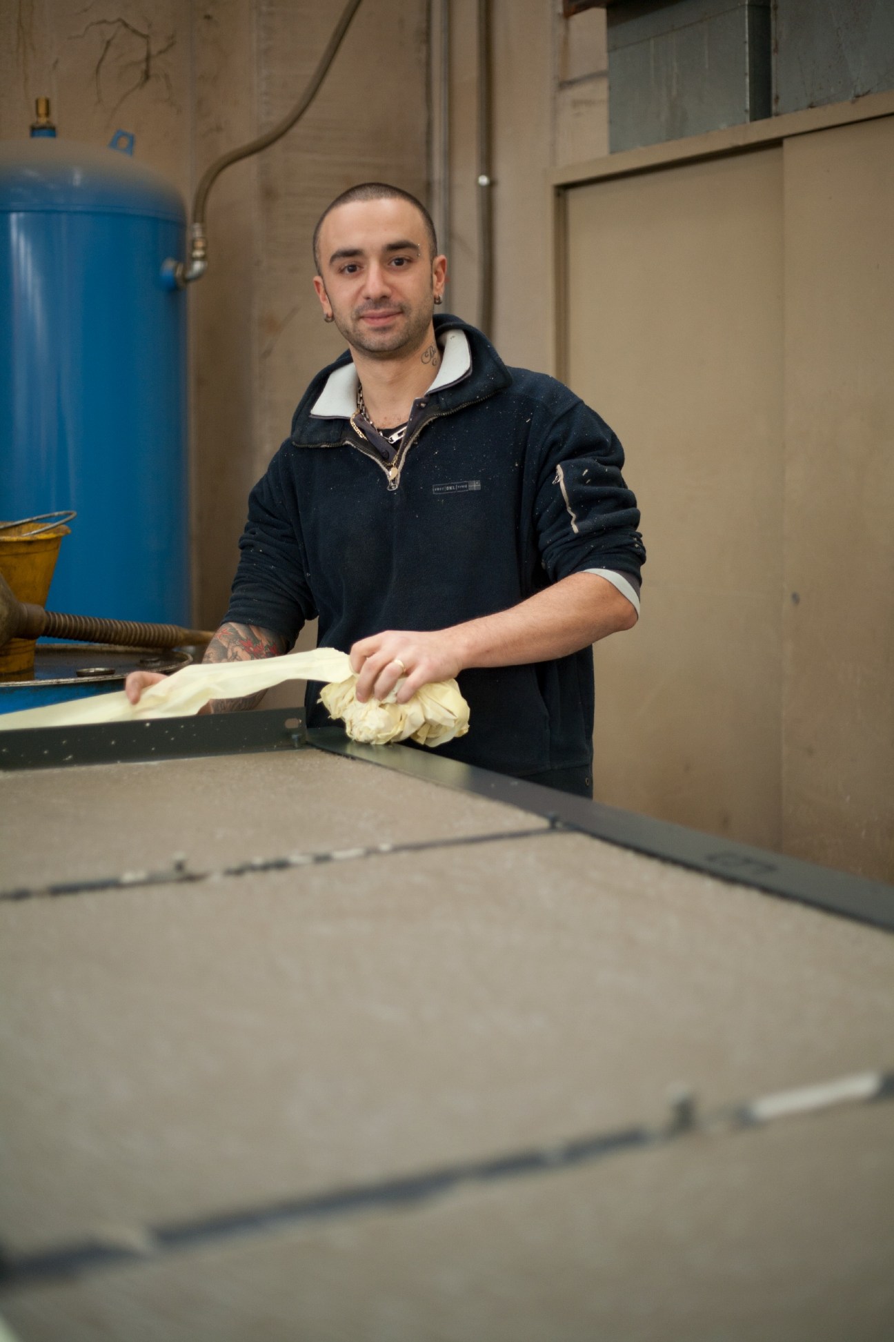 Worker at Parma Antonio & Figli applies cement lining to safe walls during manufacturing.