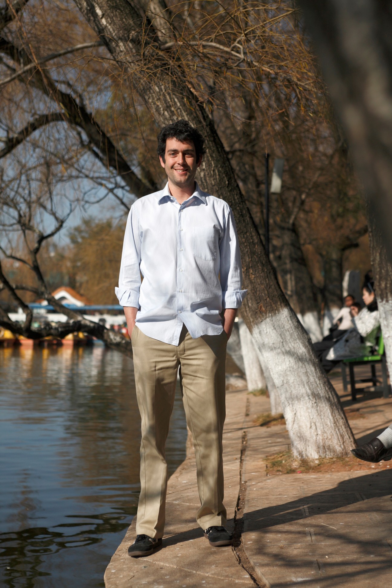 Chris Horton stands by a tree beside a waterway at Green Lake in Kunming, China.