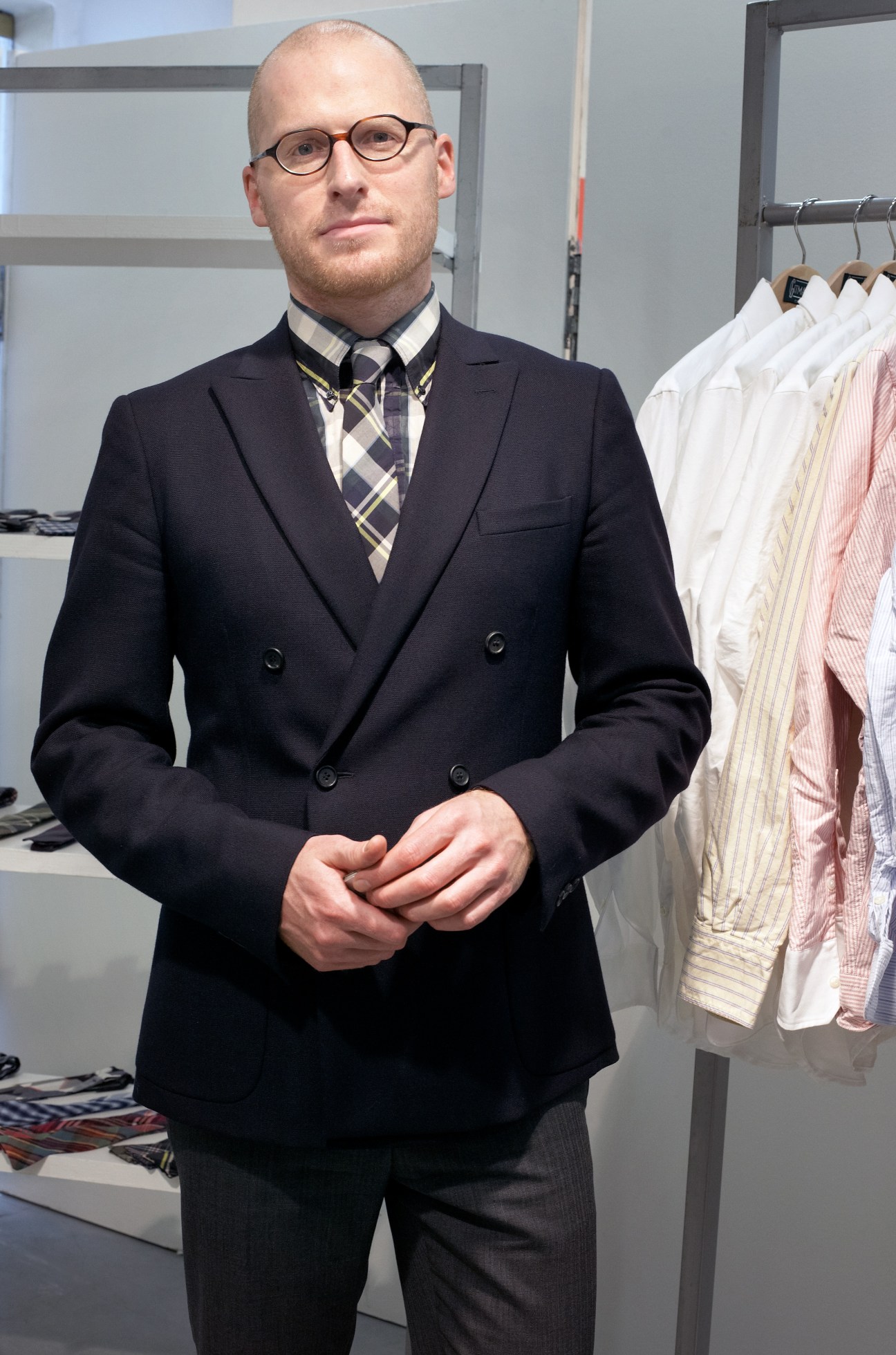 Christopher Olberding, vice president of sales at Gitman Brothers, stands in a showroom wearing a navy blazer and plaid tie.