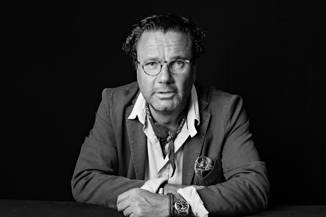 Black and white portrait of Christoph Hoffmann, CEO of 25hours Hotels, wearing glasses and a blazer.
