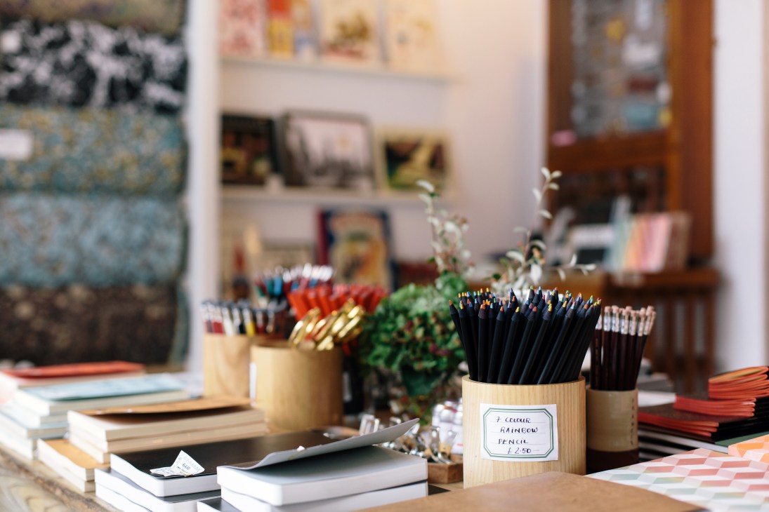 Display of colored pencils in wooden holders at Choosing Keeping stationery shop in London.
