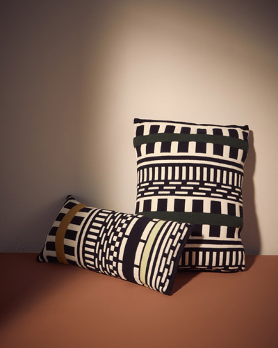 Two striped cylindrical cushions with black and white geometric patterns designed by Nathalie Du Pasquier.
